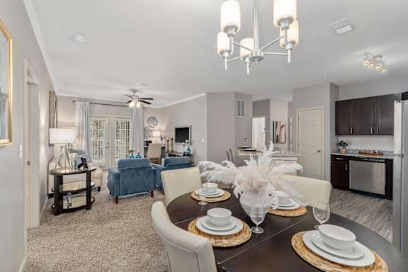 A dining room with a table set for a meal.