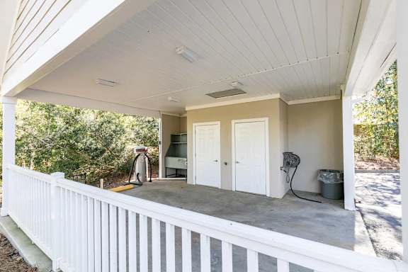 A white porch with a white railing and a white ceiling.