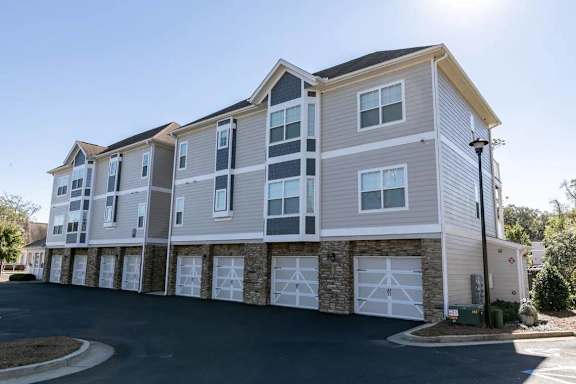 A large two-story apartment building with a garage on the ground floor.