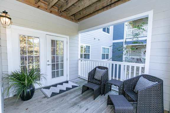 A balcony with a chair and a potted plant.