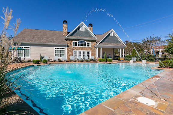 A house with a pool in front of it.