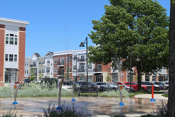 a fountain in a park in front of some buildings