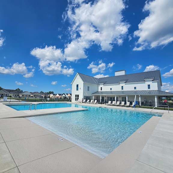 a large swimming pool with a white building in the background