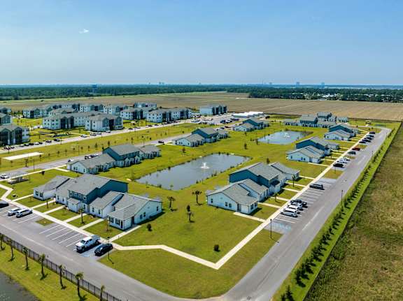 an aerial view of a neighborhood of houses in a field and a parking lot