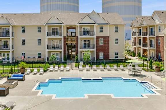 A large swimming pool in front of apartment buildings.
