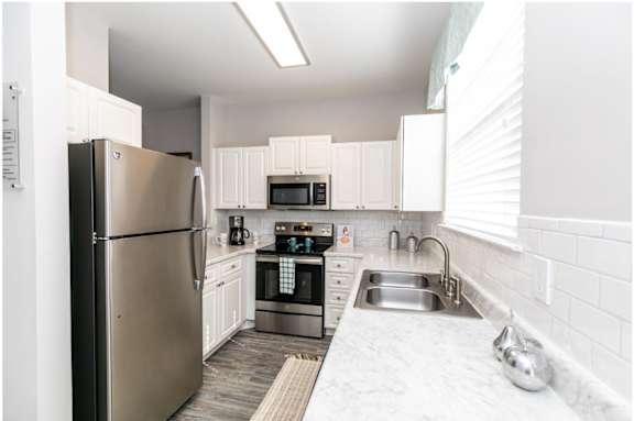 A modern kitchen with stainless steel appliances and white cabinets.