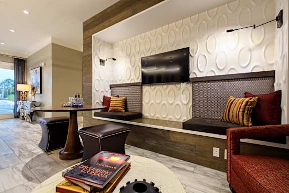 A living room with a brown couch and a white table.
