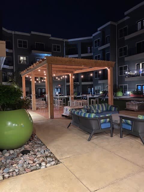 A patio area with a wooden pergola and seating area.