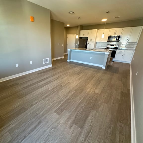 A kitchen with a grey countertop and wooden flooring.