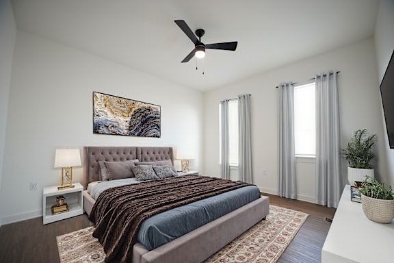Bedroom with ceiling fan and wood-style flooring at West Row Lofts and Townhomes in Birmingham, AL