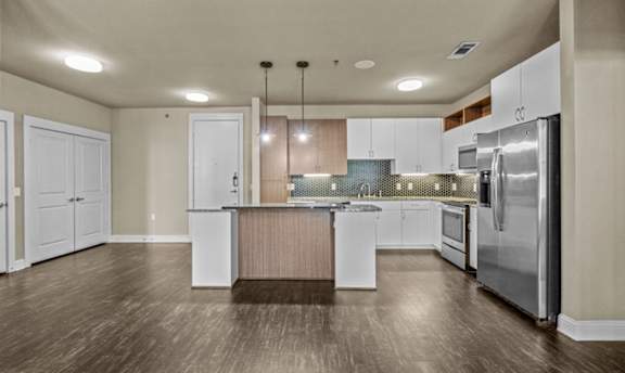 Modern kitchen with white cabinets and mosaic backsplash at Matilda at Lower Greenville Apartments, Texas