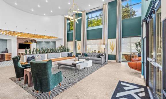 High ceiling clubhouse with teal accents and seating areas at The Mark at Midtown Apartments, Dallas, TX