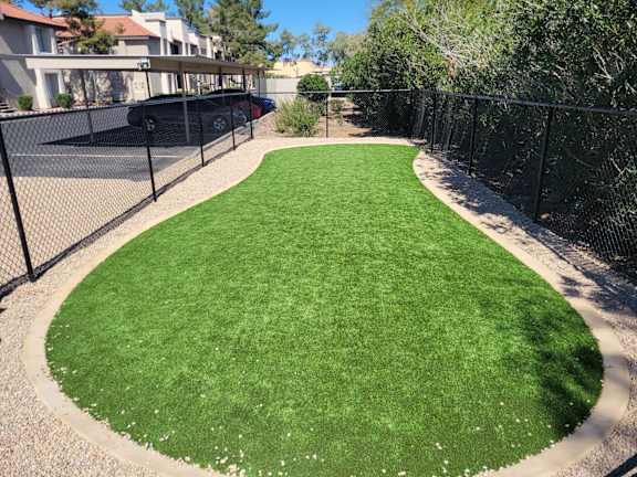 Fenced artificial turf pet area with gravel border at Gentrys Walk Apartments, Mesa, AZ