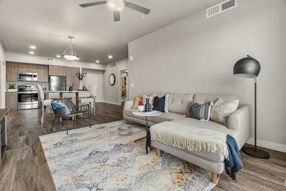 A modern living room with a white sofa and a rug.