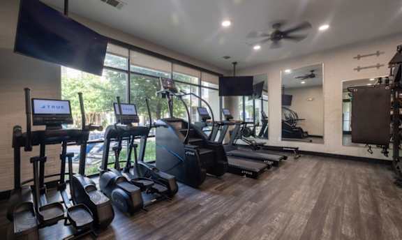 Cardio equipment room with large windows and wood flooring at The Mark at Midtown Apartments, Dallas, TX