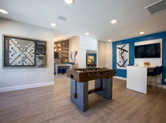 A Game Room with Plank  Flooring Foosball Table, Wall Scrabble, and Seating Areas at Enclave at Paradise Valley in Phoenix, Arizona