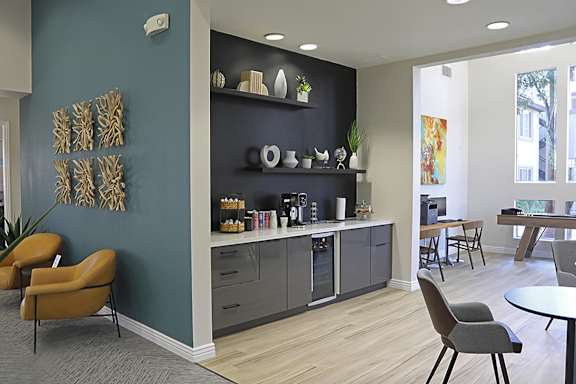 A modern office space with a blue wall and a brown chair.