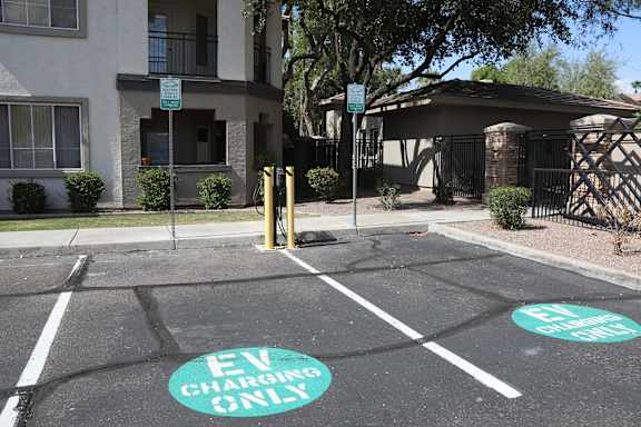 A parking lot with two spots designated for electric vehicles.