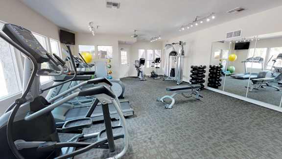 Well equipped fitness center with treadmills, elliptical machines, stationary bikes, and free weights