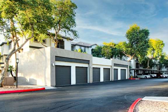 A row of garage doors are on the side of a building.