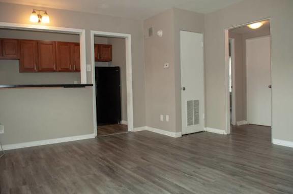 A kitchen with wooden cabinets and a black fridge.