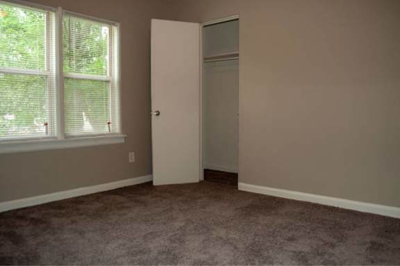 A room with a carpeted floor and a door.