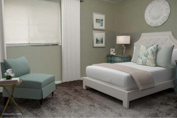 A bedroom with a large bed and a small chair.