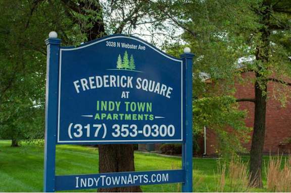 A sign for Frederick Square at Indy Town Apartments is displayed in front of a building.