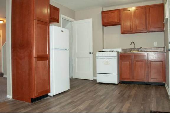A kitchen with a white refrigerator and a white stove top oven.
