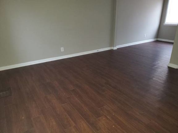 A room with wooden flooring and a window.