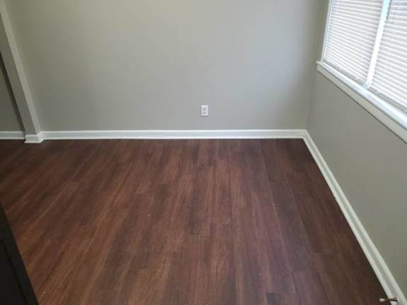 A room with a wooden floor and a window.