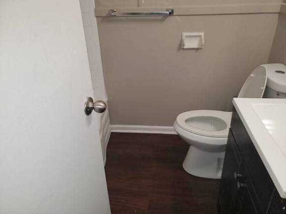 A white toilet in a small bathroom with a white door.