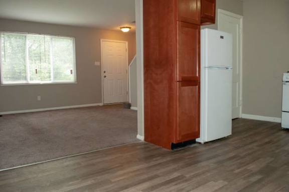 A kitchen area with a white refrigerator and a brown cabinet.