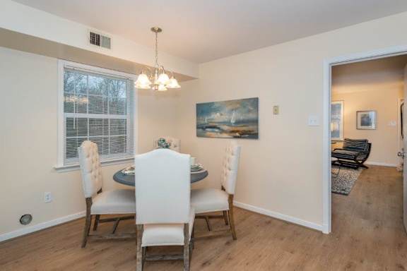 A dining room with a table and chairs.