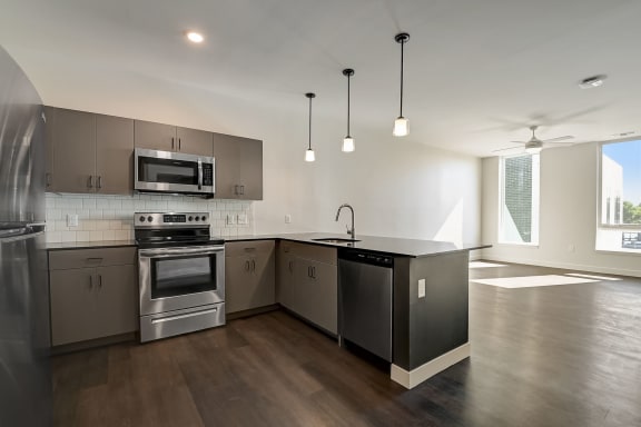 a kitchen with stainless steel appliances and an island with a black countertop