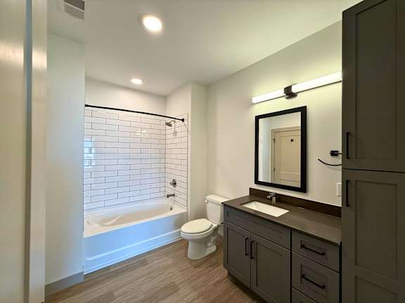 A bathroom with a white tub, sink, and toilet.