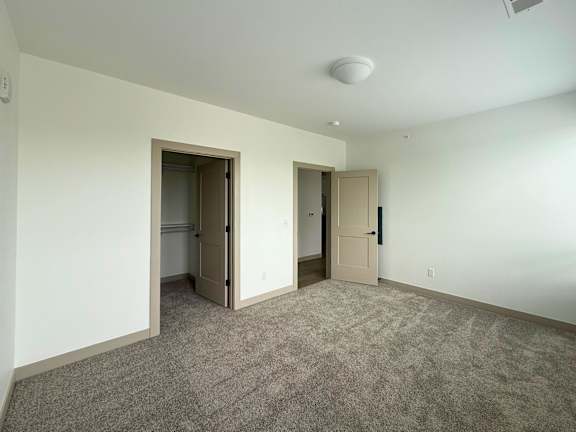 A room with two doors and a carpeted floor.