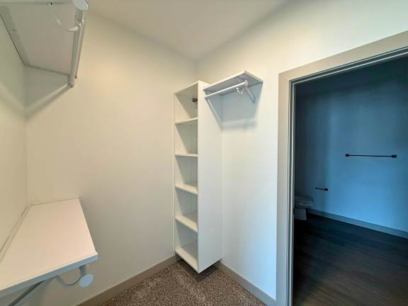 A white shelving unit in a room with a white lamp and a white table.