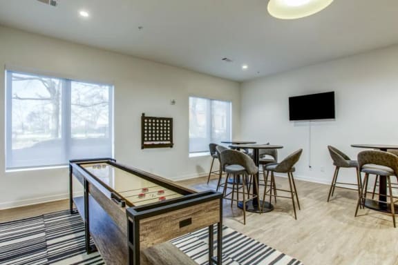 a game room with a pool table and a bar with chairs and a television
