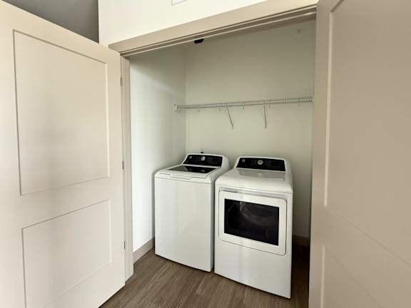 Two white front loading washing machines in a laundry room.