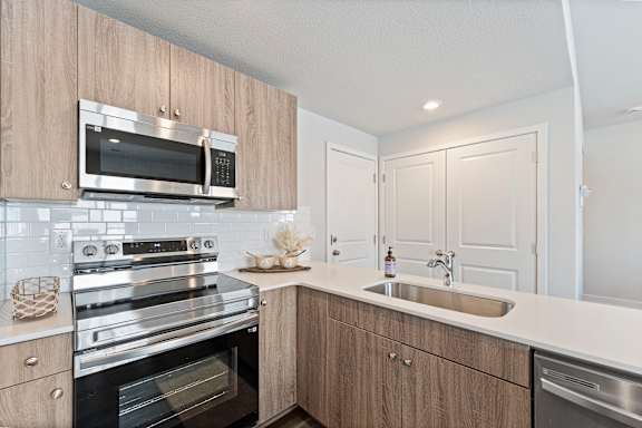 A modern kitchen with wooden cabinets and stainless steel appliances.