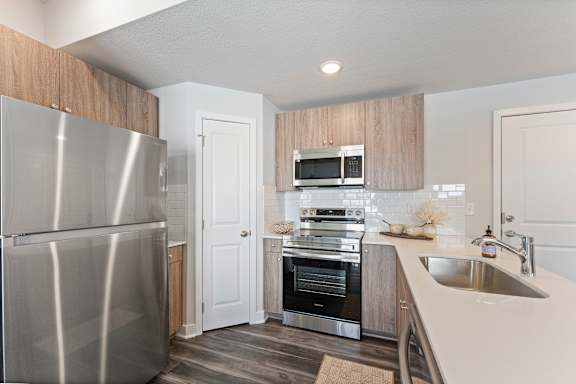 A modern kitchen with a stainless steel refrigerator and a built-in oven.