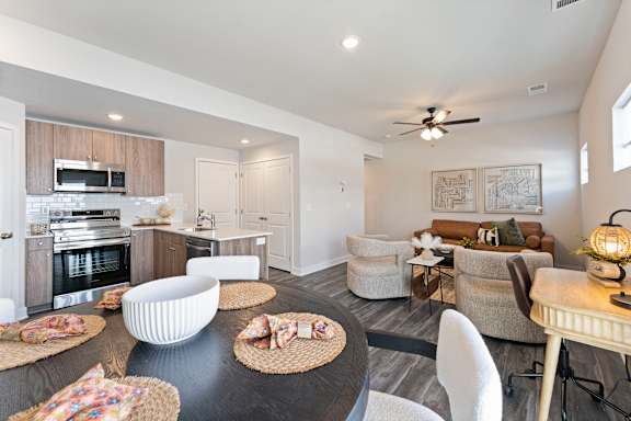 A modern kitchen with a dining area and a living room.