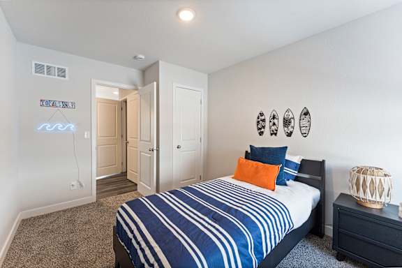 A bedroom with a bed, nightstand, and a lamp.