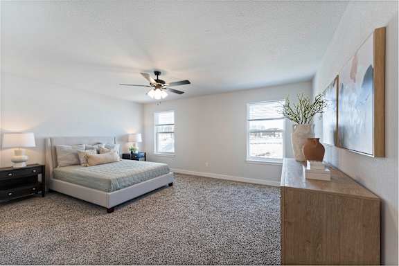 A bedroom with a bed, nightstand, and a ceiling fan.