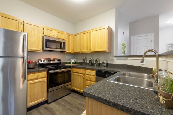 a kitchen with granite counter tops and wooden cabinets