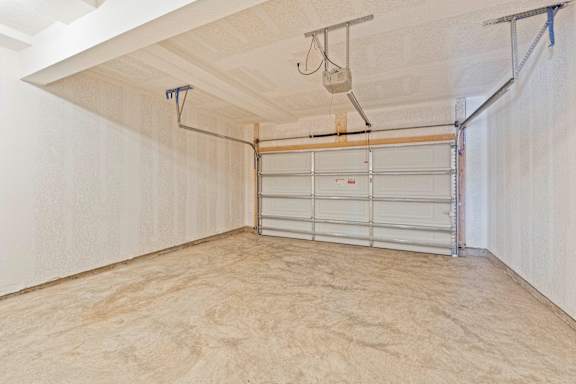 A garage with a white door and a brown floor.
