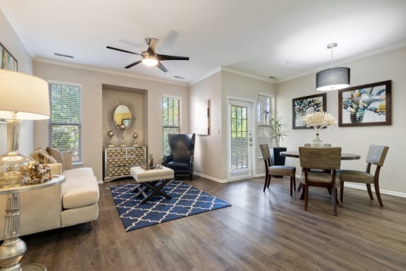 a living room with a ceiling fan and a dining room