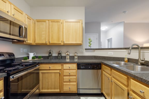 a kitchen with wooden cabinets and granite counter tops and a sink