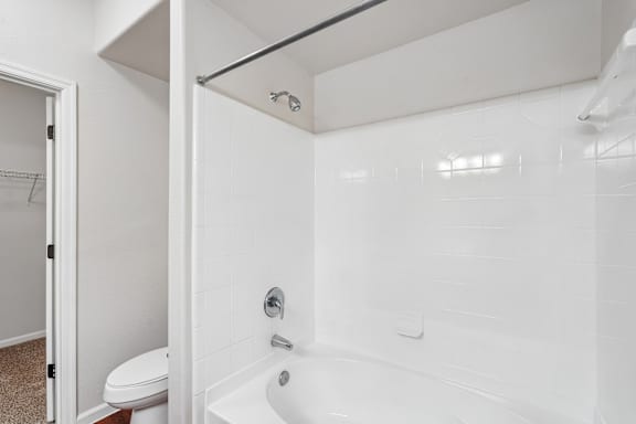 A white bathroom with a toilet and a bathtub.